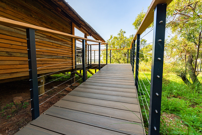 Eva-Last composite deck and glass balustrade beside a timber cabin